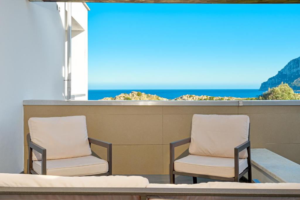 two chairs on a balcony with the ocean in the background at Villa Marconi Apartment 7 in Golfo Aranci