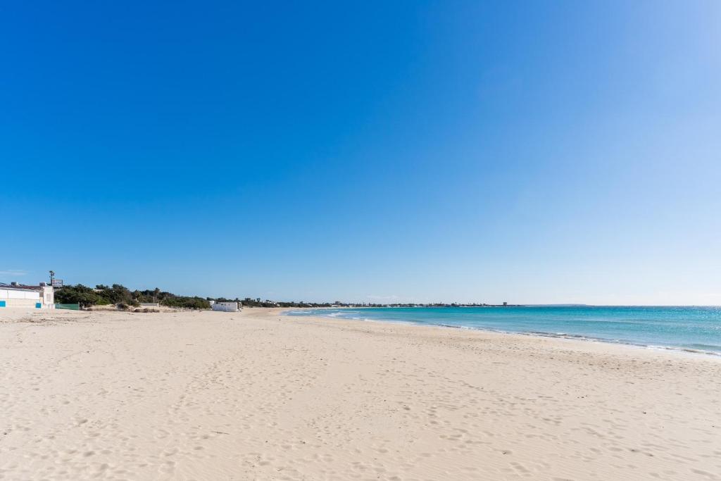 a sandy beach with the ocean in the background at Villa Tina a Torre Lapillo in Torre Lapillo