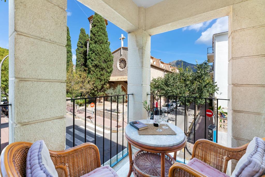a balcony with a table and chairs and a church at Ca Na Bel in Port de Soller