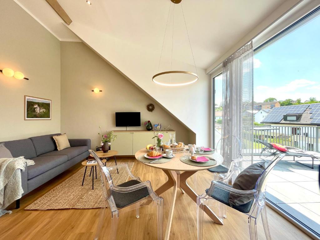 a living room with a couch and a table and chairs at Ferienwohnung Fernblick in Königsberg in Bayern