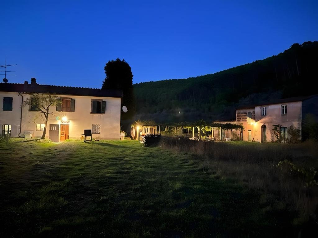 a house in a field at night with lights at Tuscany Charme Coselli Restored in Capannori