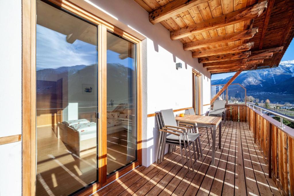 a balcony of a house with a table and chairs at Langstein Wohnung Rose in Coldrano