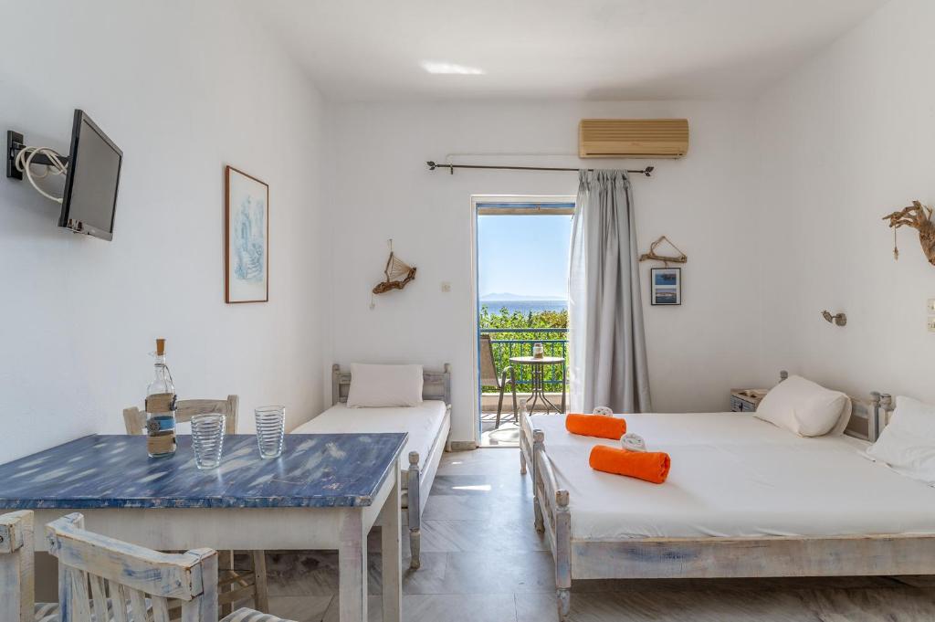 a room with two beds and a dining table at Perasma Studio 1 in Kipri