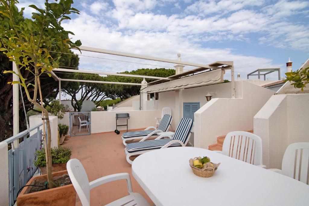 a balcony with a white table and chairs at Villa Apfel in Vale do Lobo