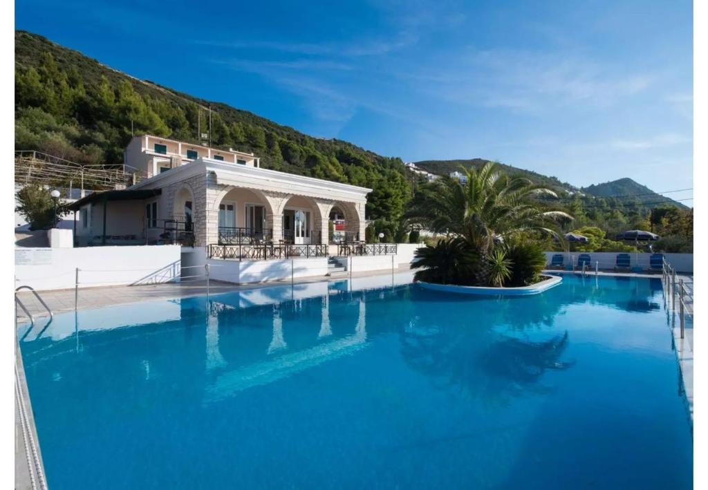 a large pool with blue water in front of a building at Sunset Premium Studio 6 in Lefkada