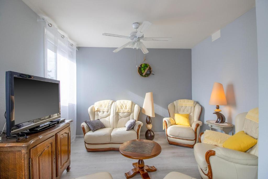 a living room with chairs and a flat screen tv at Lumineux Le Bugue in Le Bugue