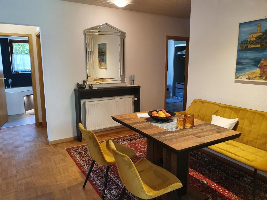 a living room with a table and a yellow couch at Stadler in Langenargen