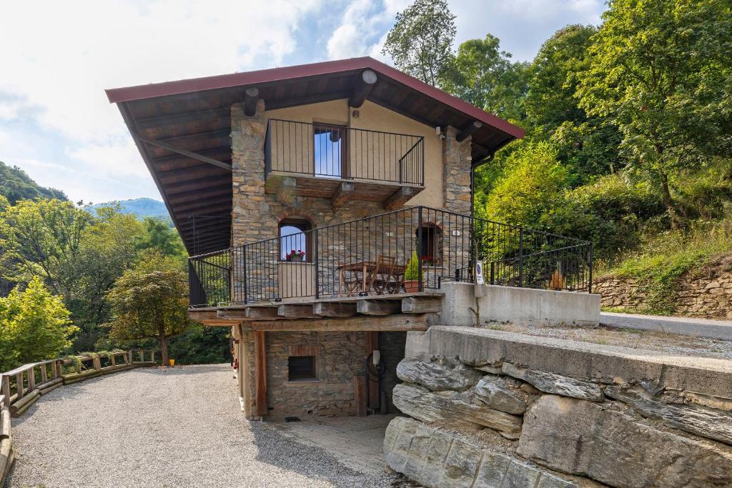a house with a balcony on top of a stone wall at Lo Sarvanot in Bernezzo