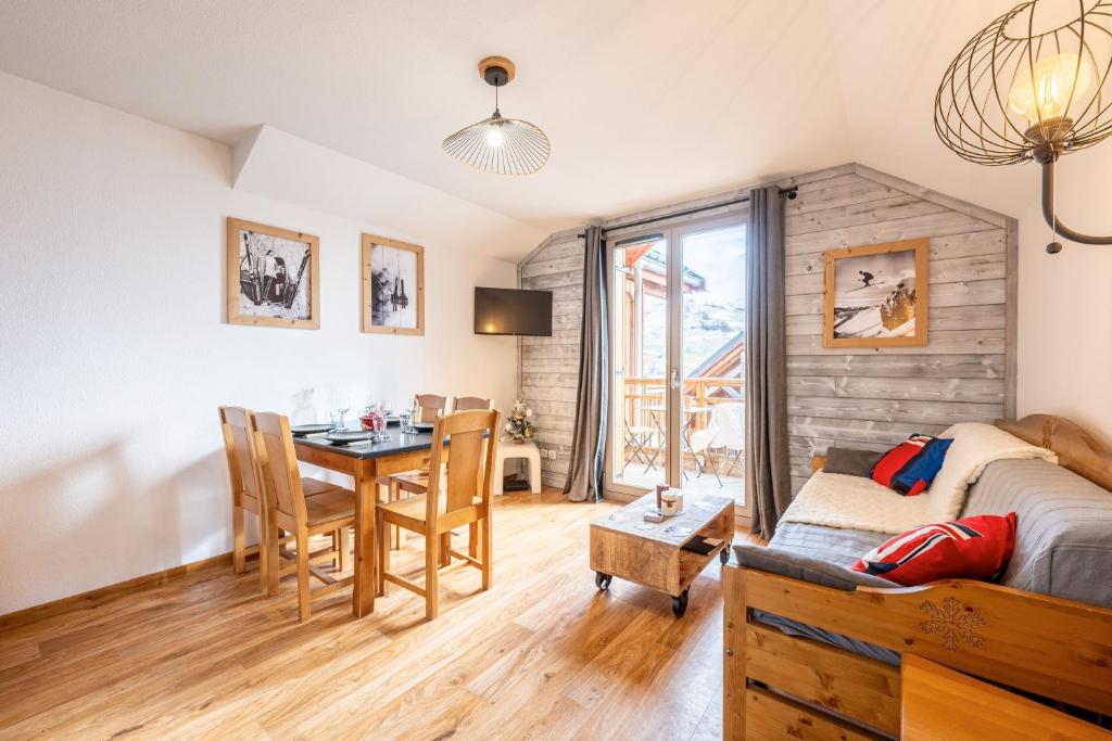 a living room with a table and a bedroom at Appartement Atlas in Albiez-Montrond