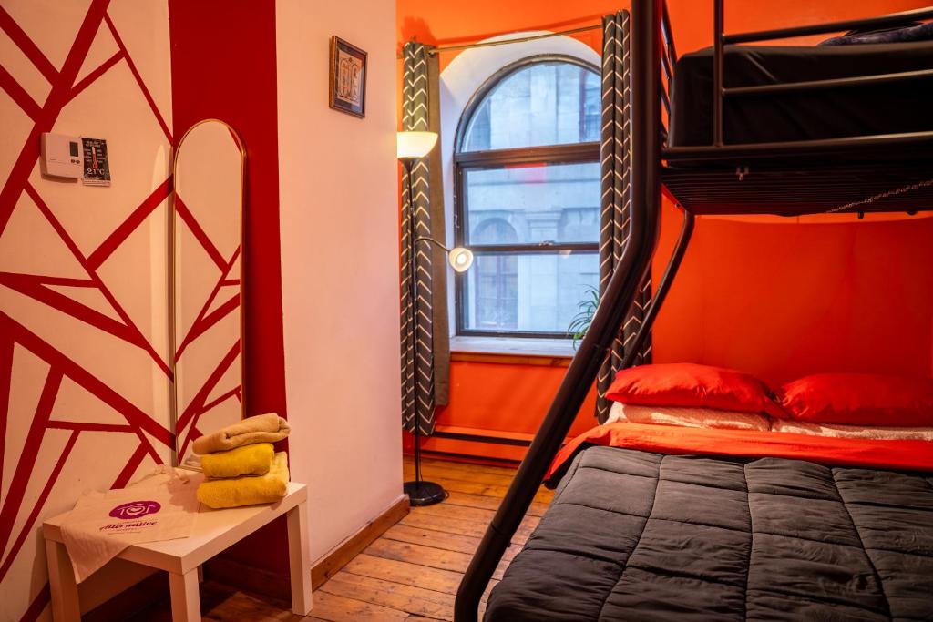 a bedroom with a bunk bed and red walls at Auberge Alternative in Montreal