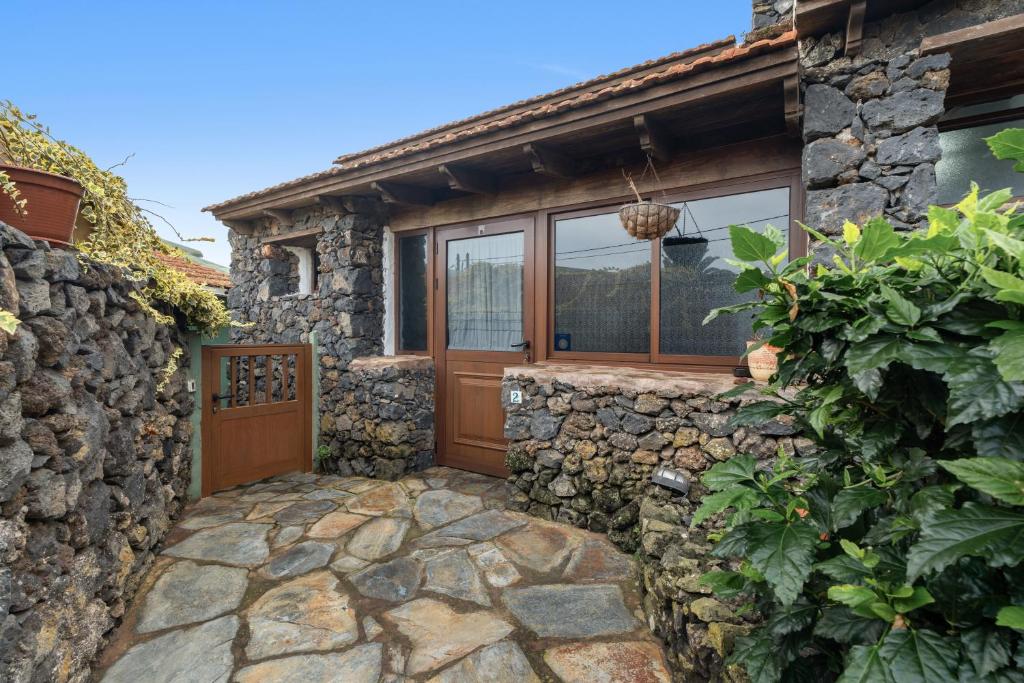 a stone house with a wooden door and a stone wall at Tesbabo Rural - Mimo in Mocanal