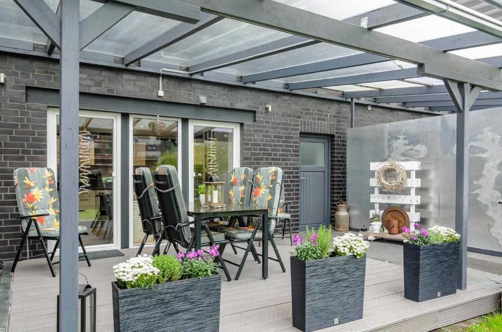 a patio with chairs and a table on a deck at Femeer 01 in Wilhelmshaven