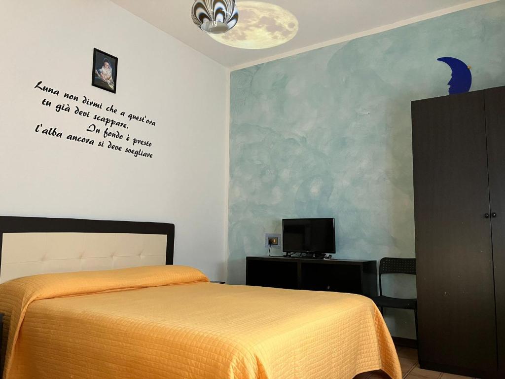 a bedroom with a bed with a yellow blanket on the wall at Luna Apartment in Rimini