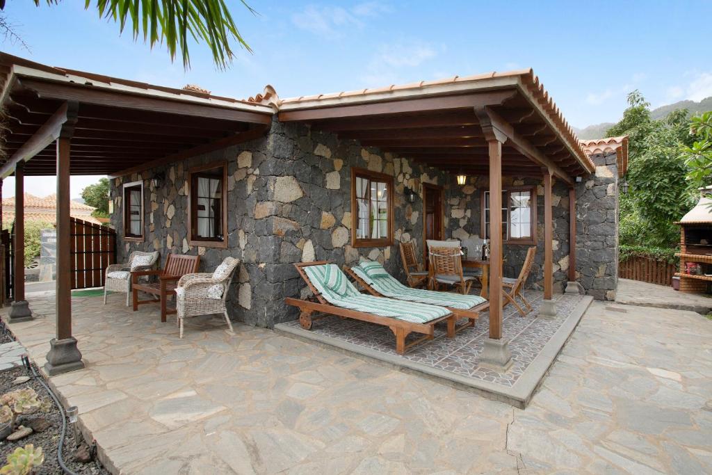 a patio with a stone house with a roof at Casa Rural Arecida in Tijarafe