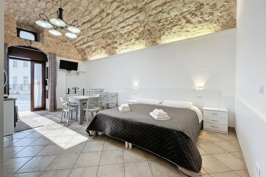 a bedroom with a bed and a table with chairs at La Castellana in Monte SantʼAngelo