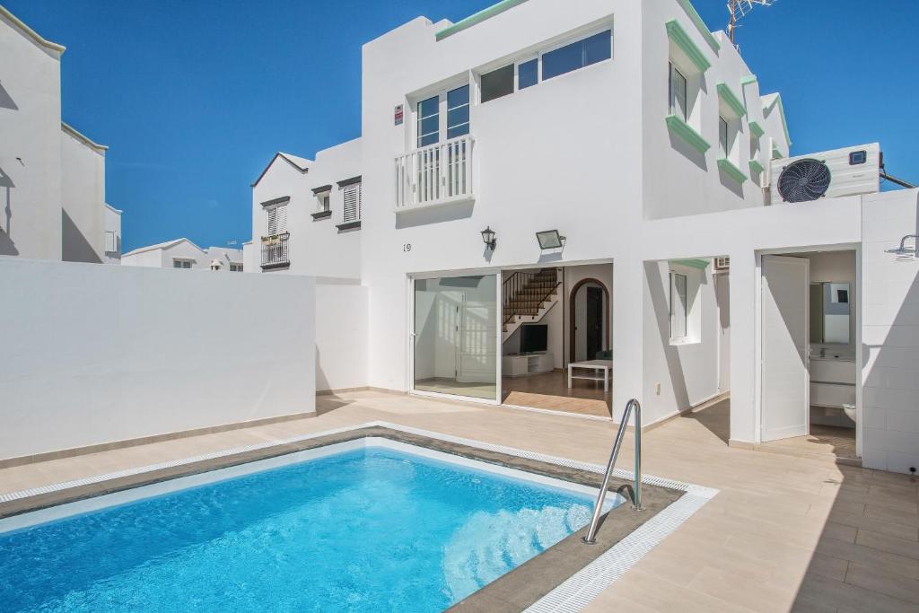 a white house with a swimming pool in front of it at Casa Oasis in Tías