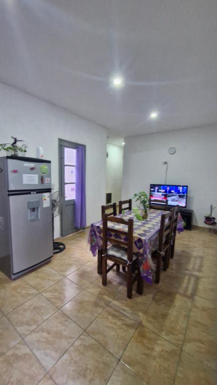 a living room with a table and a kitchen with a tv at Dpto 6 in La Cieneguita