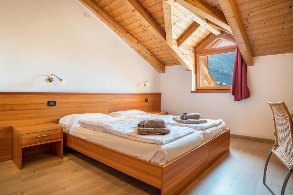 a bedroom with a bed and a window at Casa Mirtillo Batistei in Molveno