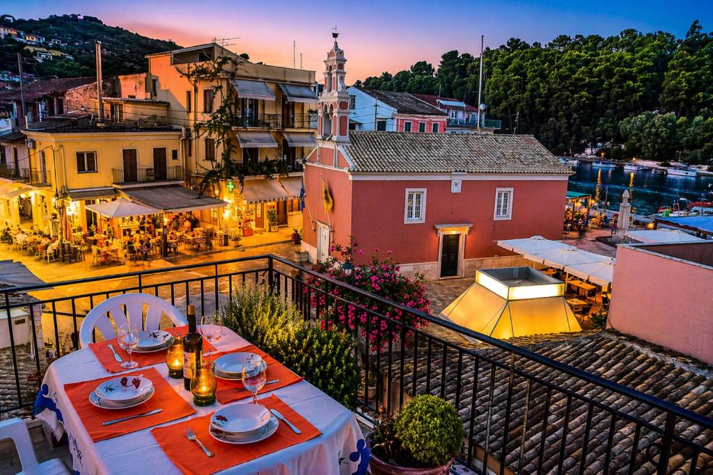 a view of a town with a table on a balcony at Jenny Apartment in Gaios