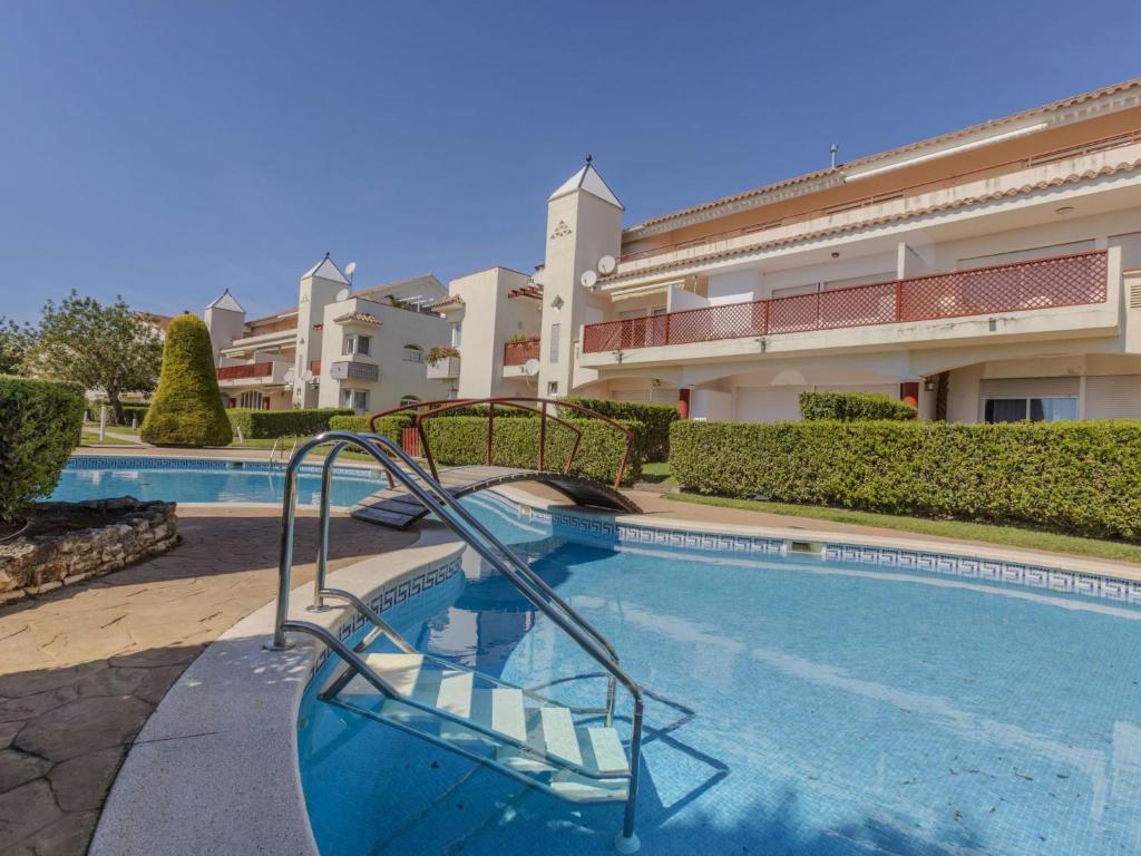 a swimming pool with a slide in front of a building at Apartment Coco Golf by Interhome in Sant Jordi
