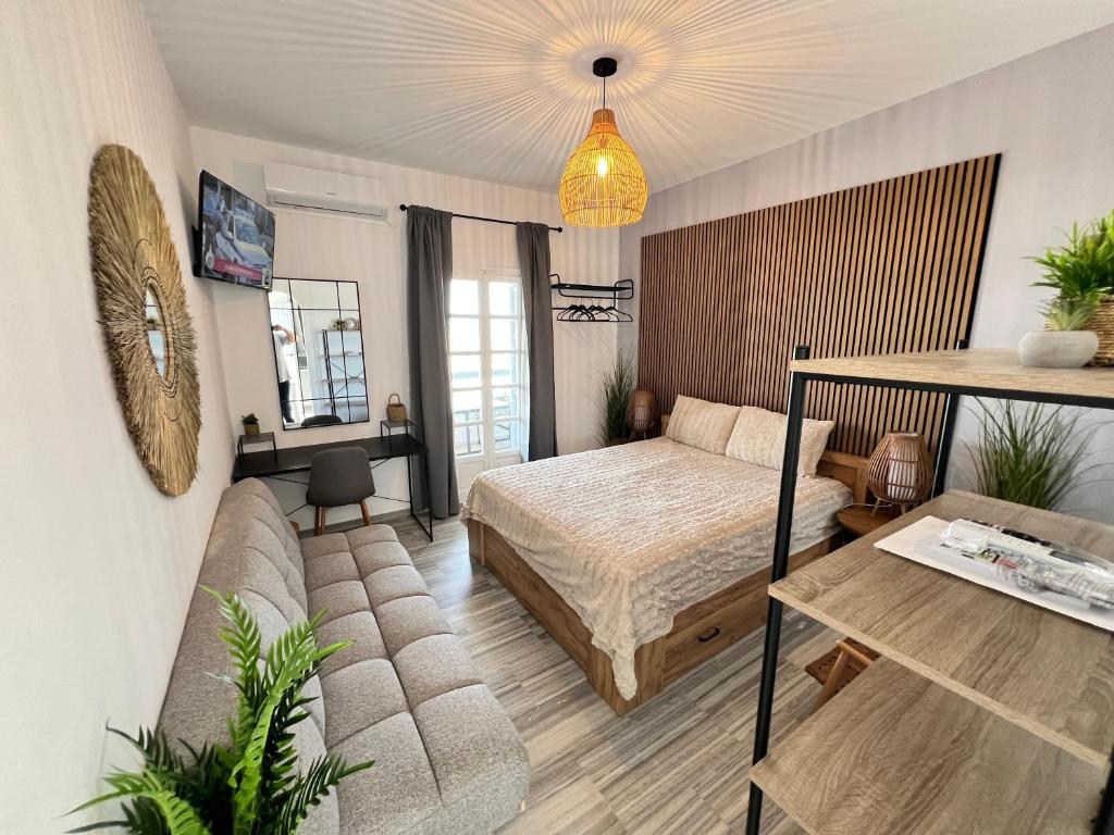a bedroom with a bed and a couch at aeolian blu 3 in Parikia