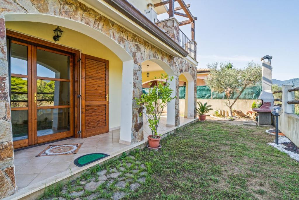a house with a wooden door and a yard at Villamara in Olìa Speciosa