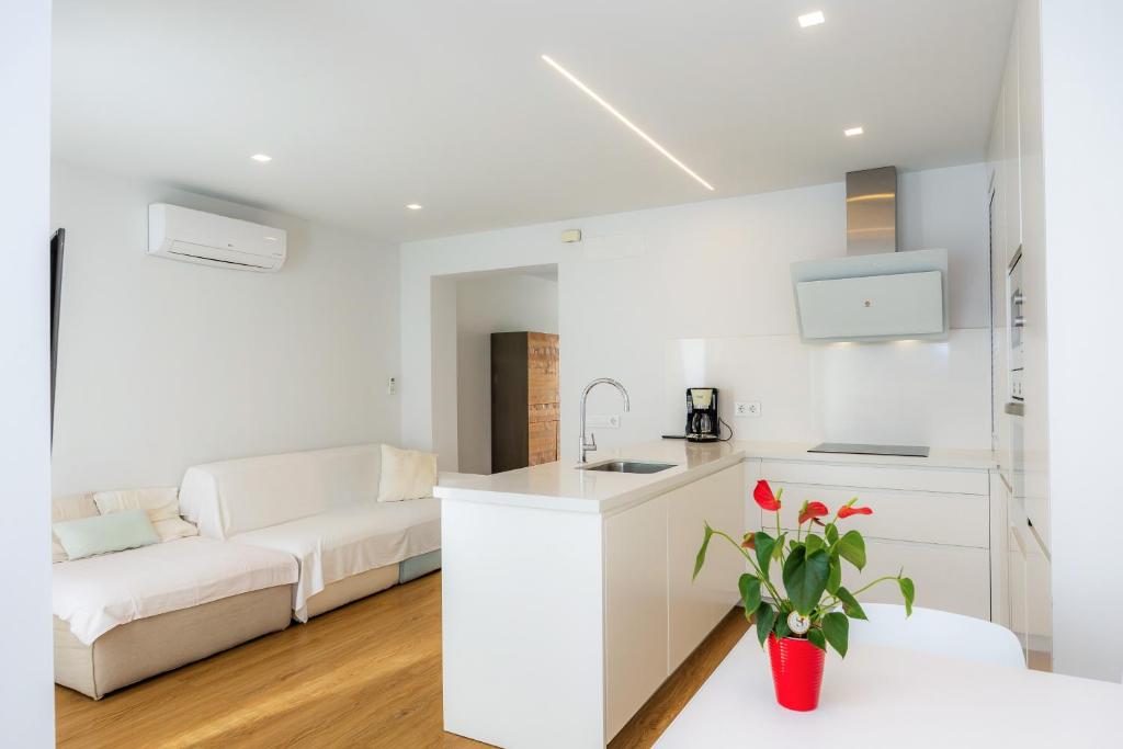 a white kitchen and living room with a white couch at Ca Na Tonina Ref 7000 in S'Illot