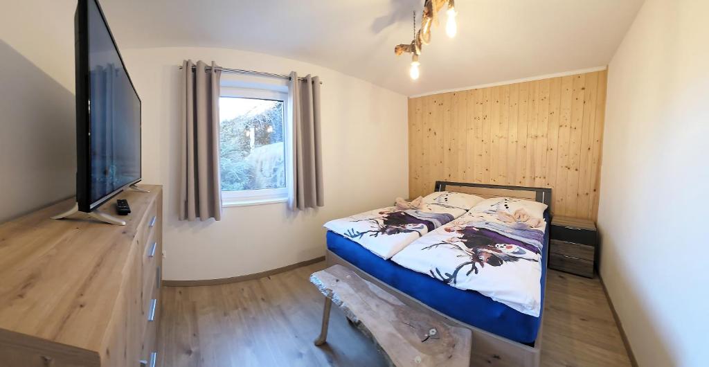 a small bedroom with a bed and a television at Konis Ferienwohnung - barrierearm in Rangersdorf