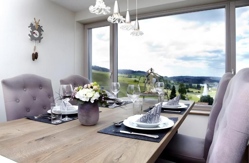 a dining room with a table with chairs and a large window at Chillout in Ibach