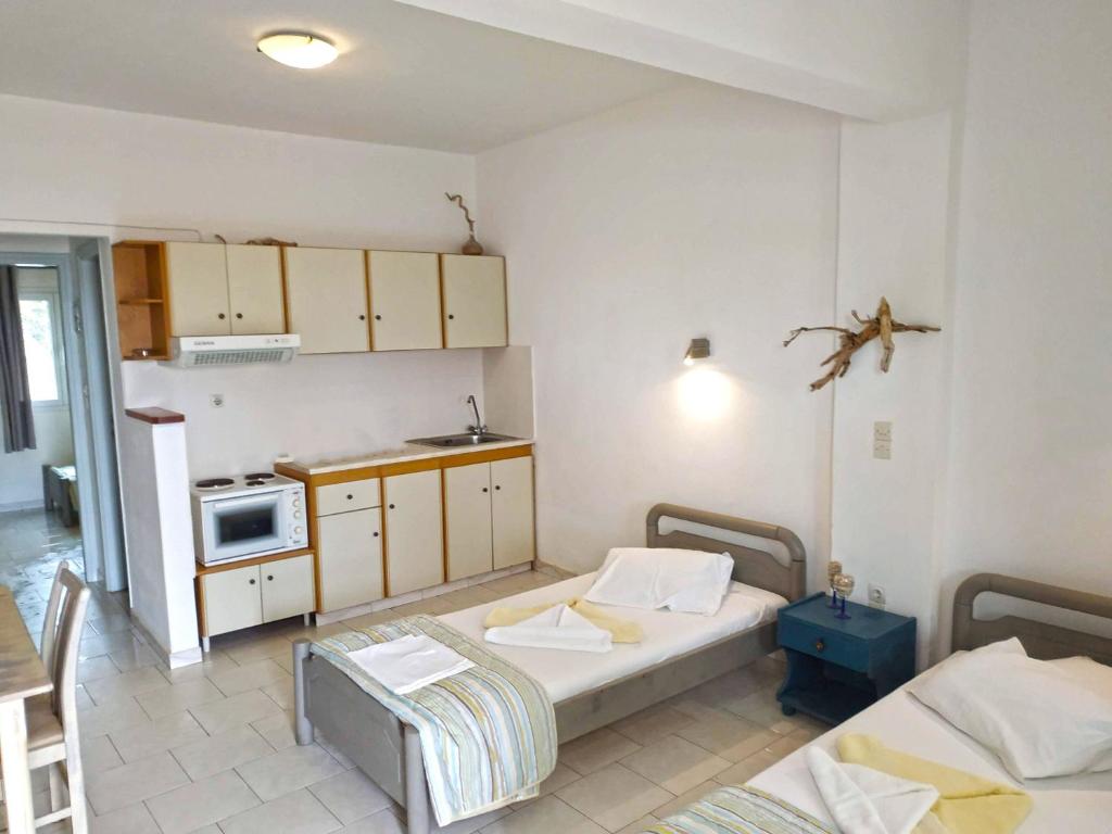 a small room with two beds and a kitchen at Perasma Studios 11 in Kipri