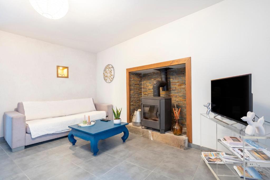a living room with a couch and a fireplace at Ce Petit Penty in Douarnenez