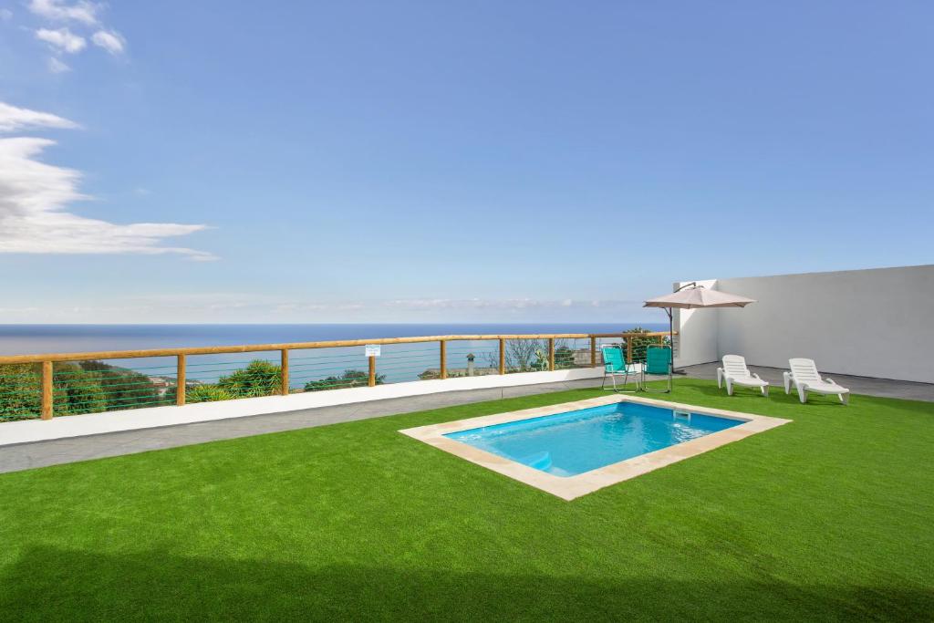 ein Garten mit Swimmingpool und grünem Rasen in der Unterkunft Stevier in Icod de los Vinos