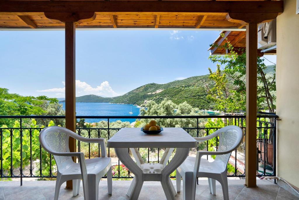 a table and chairs on a balcony with a view of the ocean at Vardia studio A in Mikros Gialos