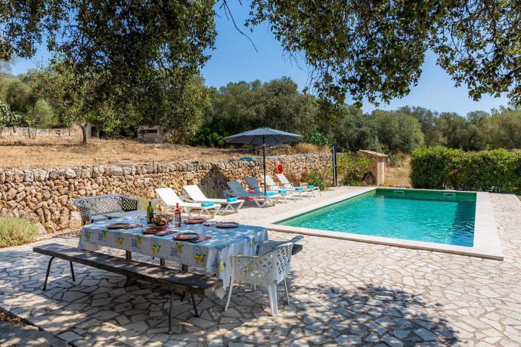 a patio with a table and chairs next to a pool at Can Gallot De Punxuat - Pool in Algaida