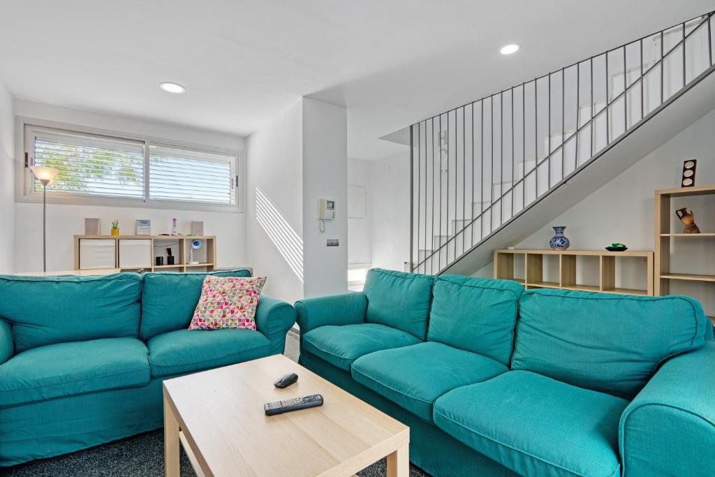 a living room with a blue couch and a table at Albalat Tarongers in Albalat de Taronchers