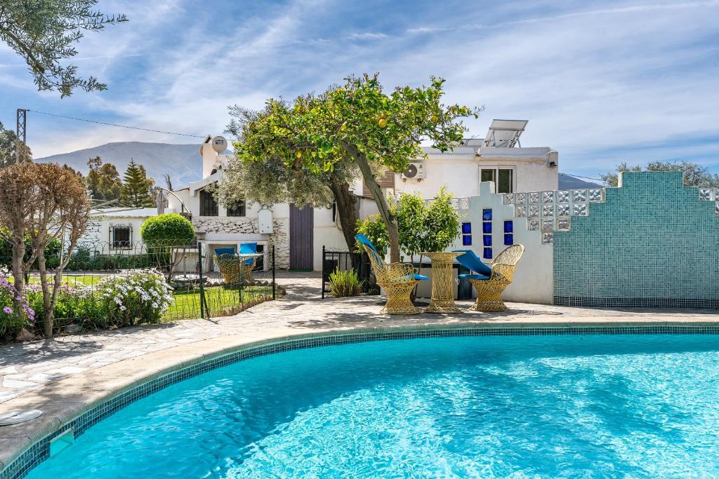 a swimming pool in front of a house at El Nido holiday cottage with pool in Órgiva