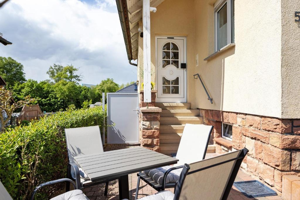 a patio with a table and chairs in front of a house at Ferienwohnung Rhön-Kutscher in Buttlar