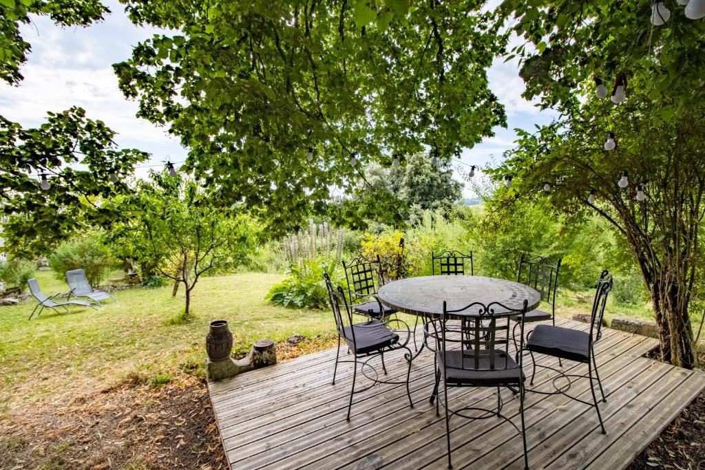 a table and chairs sitting on a wooden deck at Gite des Bois du Charme in Chalais