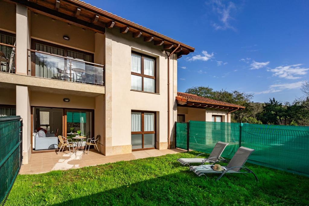 a house with two chairs in the yard at 4 Jardin- Puerto Chico in Llanes