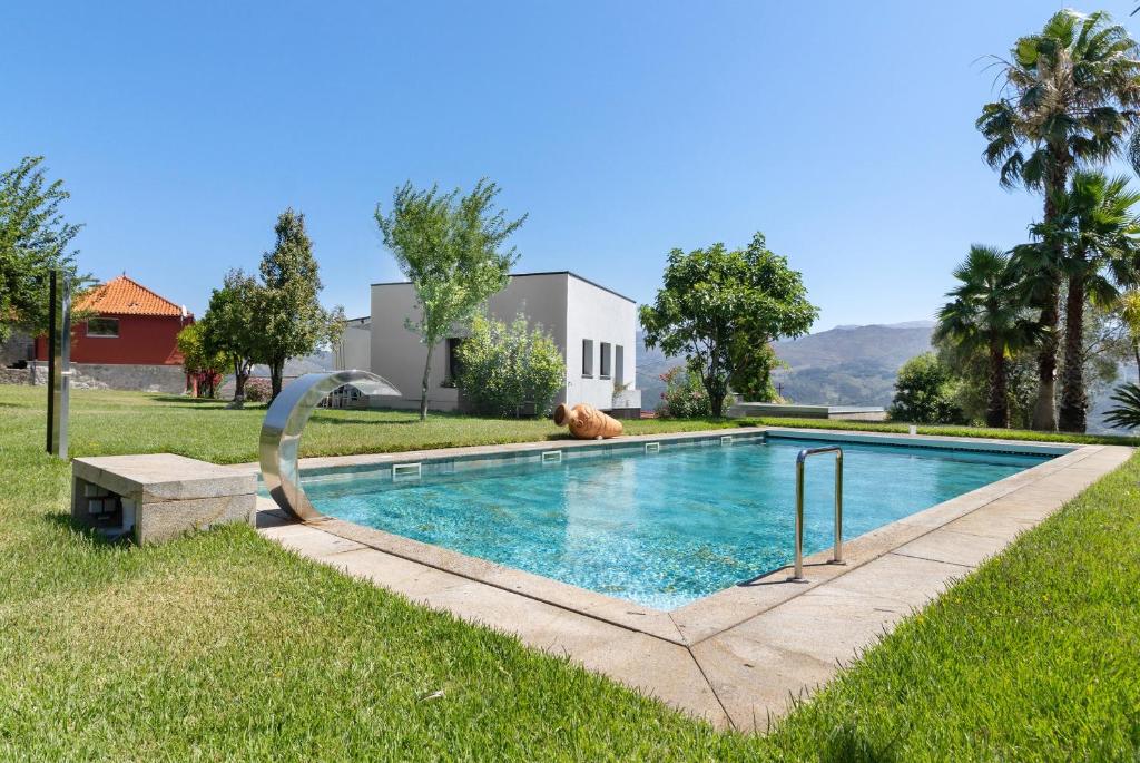 a swimming pool with a slide in the grass at Quinta Santa Marinha in Arcos de Valdevez