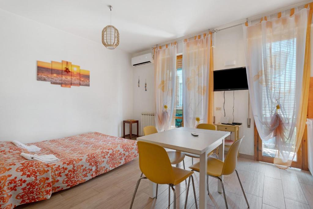 a bedroom with a bed and a table and chairs at Coral House Viareggio in Viareggio