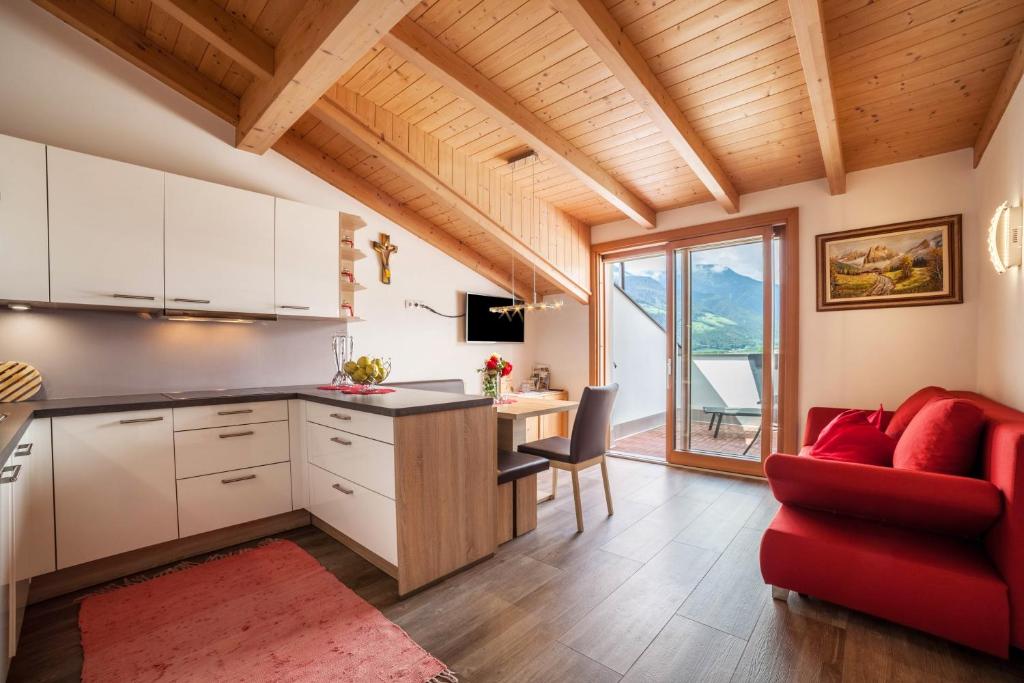 a kitchen with a red couch and a table at Sagschneiderhof Red Delicious in Plaus