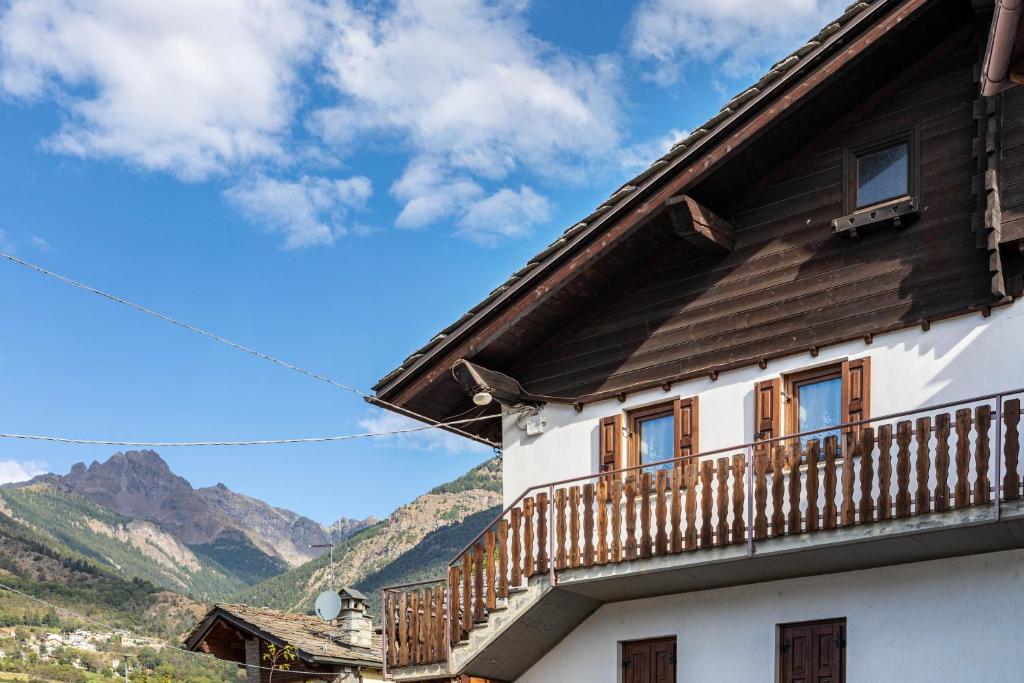 a house with a balcony and mountains in the background at Lo Sondzo in Nus