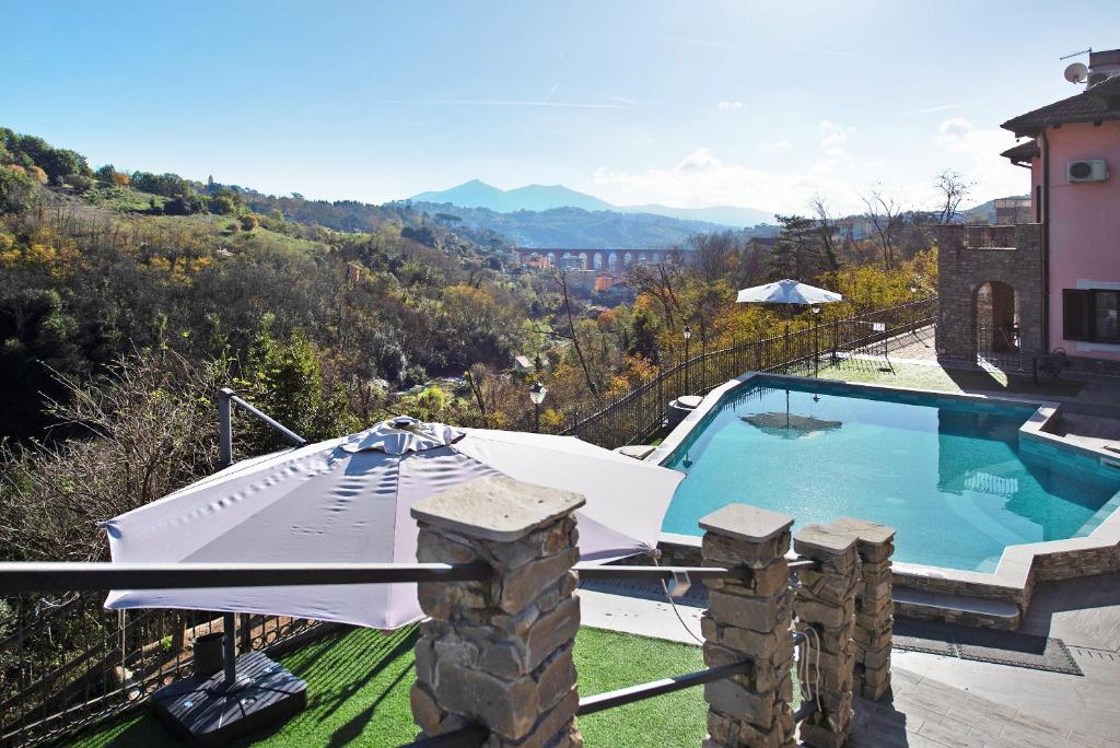 a swimming pool with an umbrella and an umbrella at Baia di Campo in Campomorone