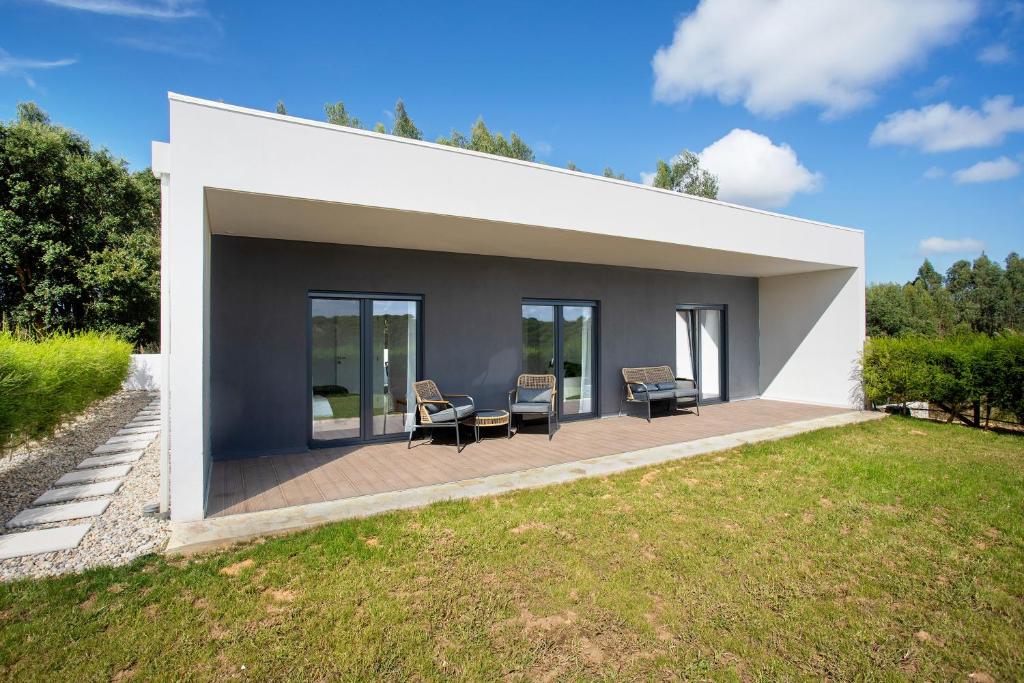 a patio with two chairs and a table on a house at Casa da Vinha in Óbidos