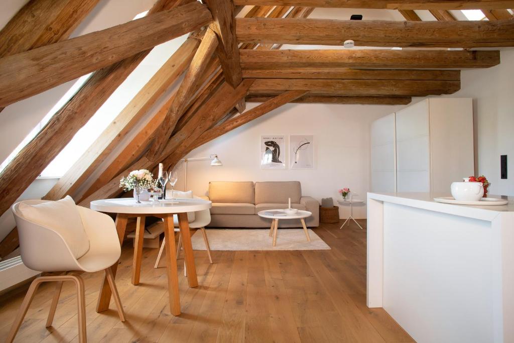 a living room with wooden ceilings and a table and chairs at Schloss Kirchberg - Schlossnest in Immenstaad am Bodensee