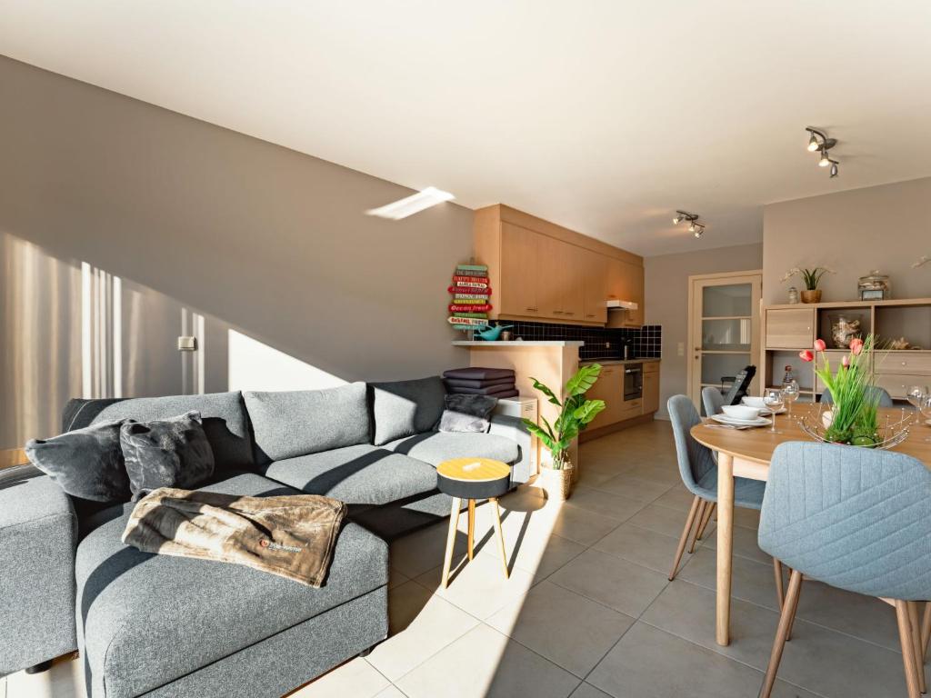 a living room with a couch and a table at Apartment Zandloper with balcony by Interhome in Bredene