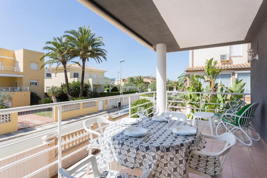 a patio with a table and chairs on a balcony at Carmen in Oliva