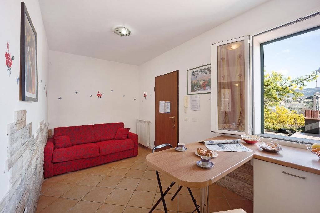 a living room with a red couch and a table at Le Mimose Bilo4 bis in Imperia