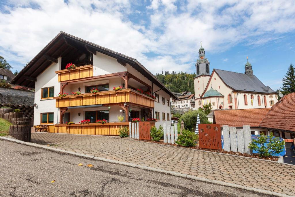 a house with a balcony and a church at Gästehaus Hanni in Todtmoos